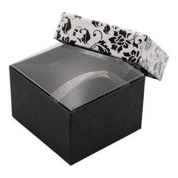 Black card box with a black and white floral design lid and black flock cushion.
Ideal for bangles and watches. Includes a clear plastic protective inner cover.
Outer edge of box measures approximately 9cm x 8cm x 5.5cm.
Pack of 12.


